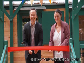 Bürgermeister Philip Schwaiger und Naturkindergartenleiterin Stefanie Müller zerschneiden das Band bei der feierlichen Eröffnung.