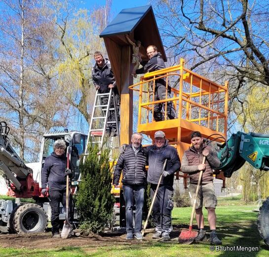 Mitarbeiter des Bauhofs stellen das Kreuz auf als Karl Koch vorbeischaut. Mengen)
